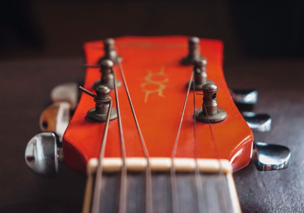 A clip-on tuner on an acoustic guitar headstock — a stand-in for the Korg Pitchclip 2 (PC-2), not a photograph of this model