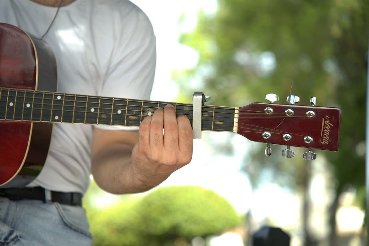 A capo clamped on the fretboard of an acoustic guitar