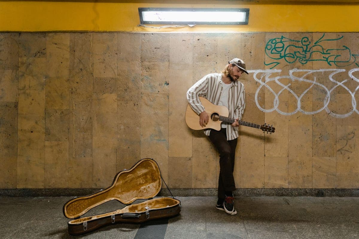 An acoustic guitar being placed into a padded case