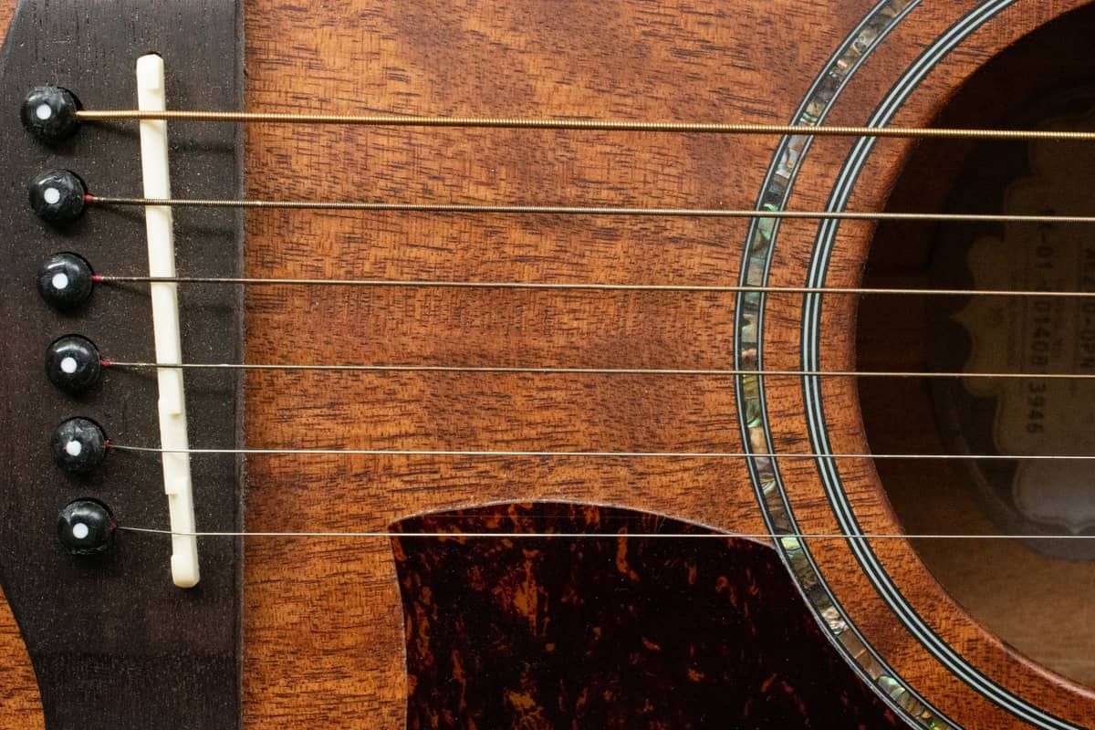 The strings and soundhole of an acoustic guitar in close-up