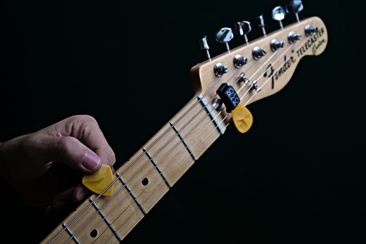 A capo resting on the headstock of a guitar