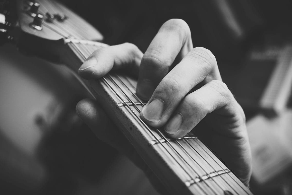 A hand fretting a chord on a guitar neck