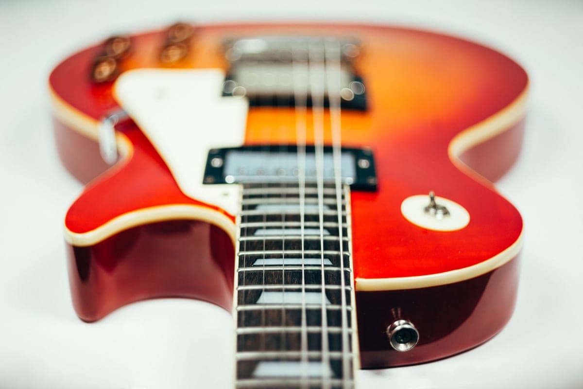 A close-up of an electric guitar neck and frets