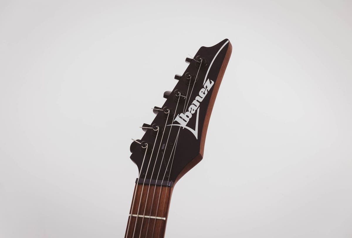 A dark rosewood fretboard being conditioned with a cloth