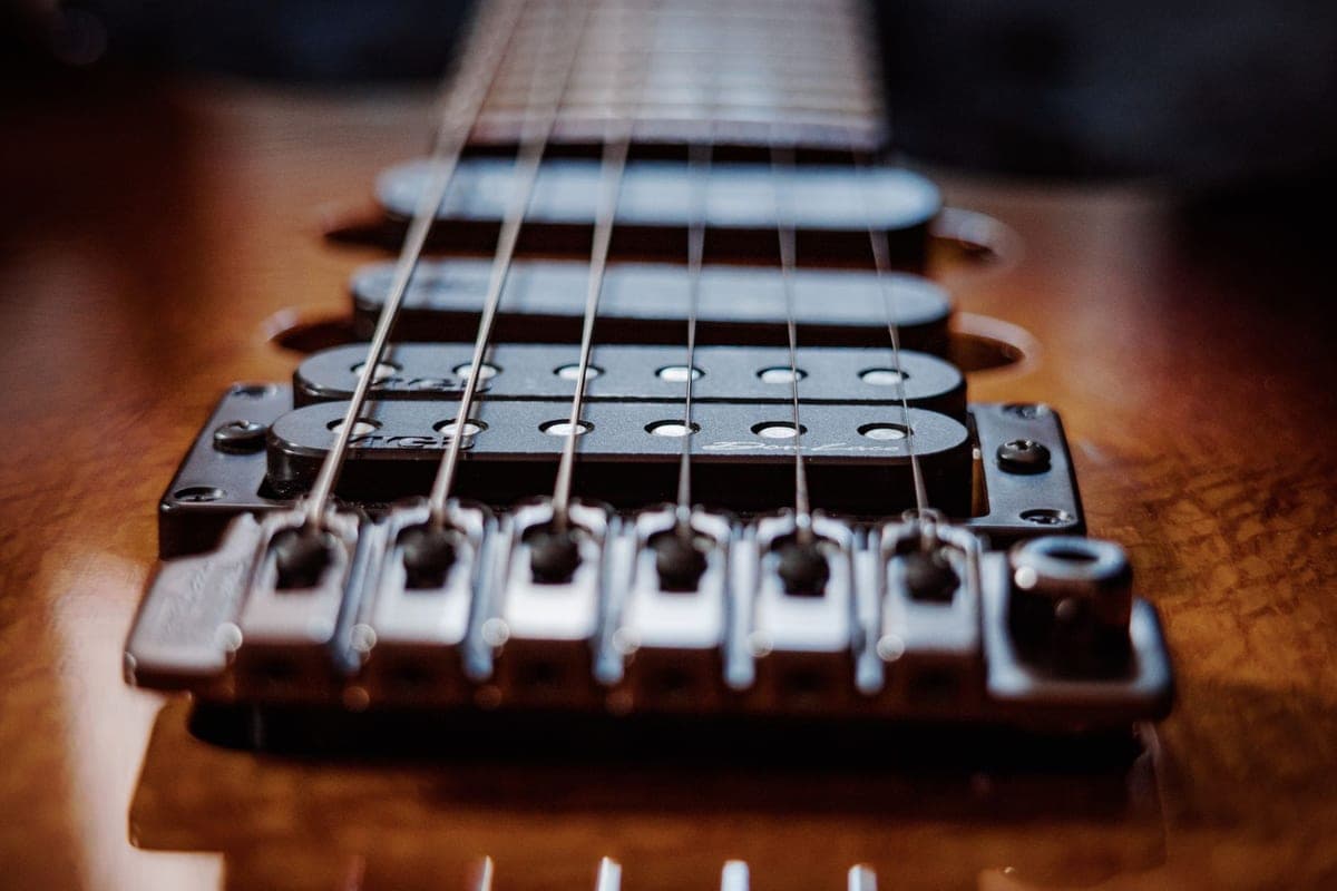 A close-up of electric guitar strings where they cross the bridge