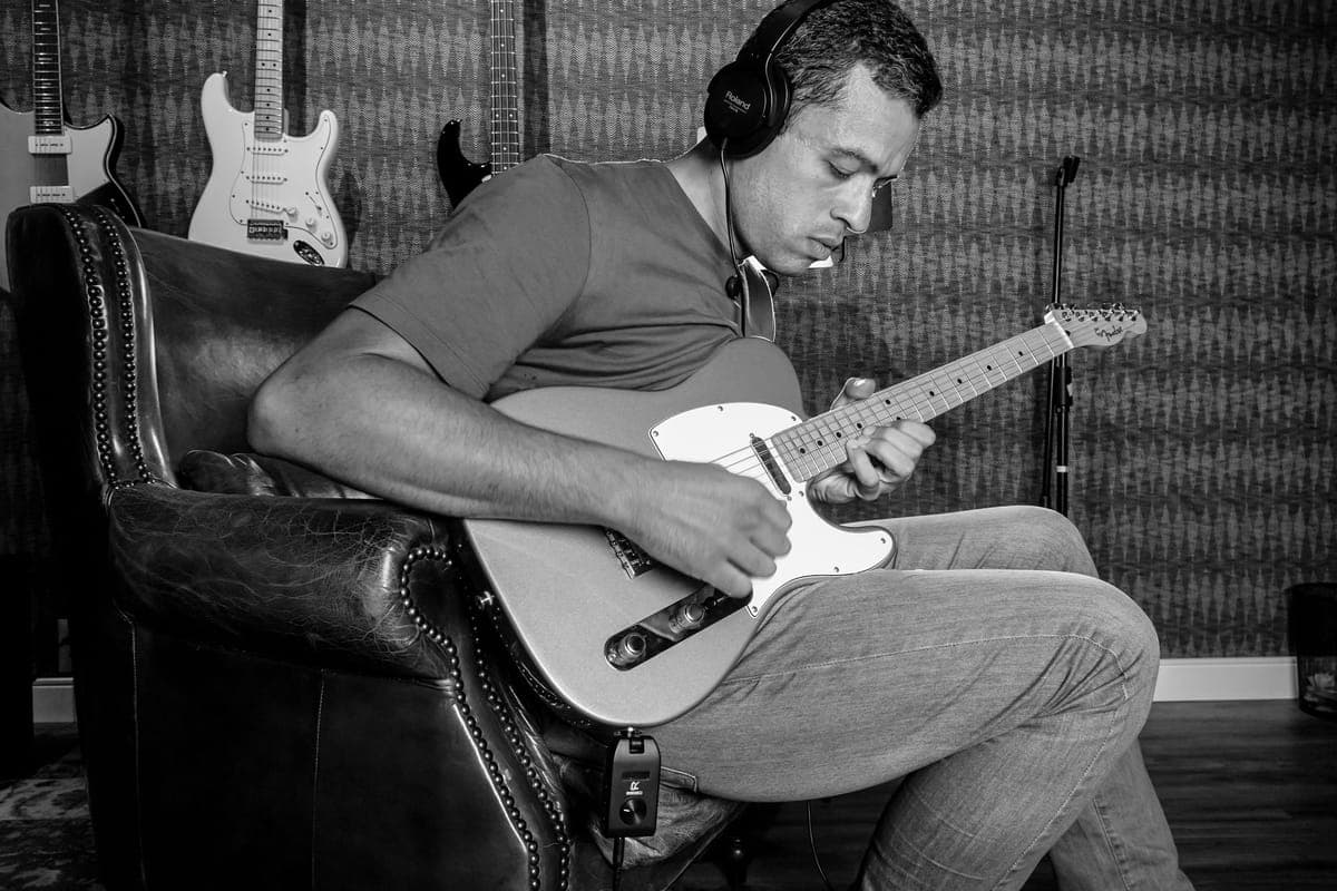 Headphones resting on an electric guitar body