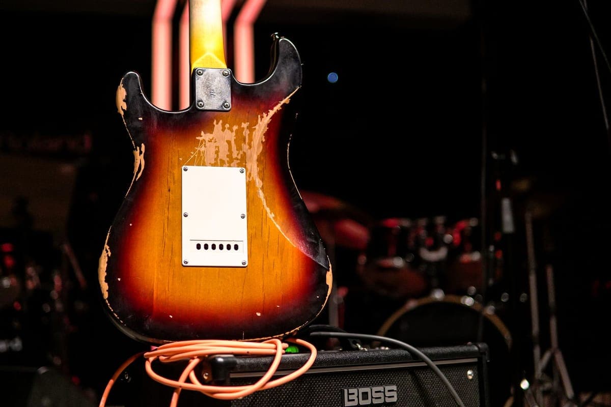 Worn guitar strings against a fretboard