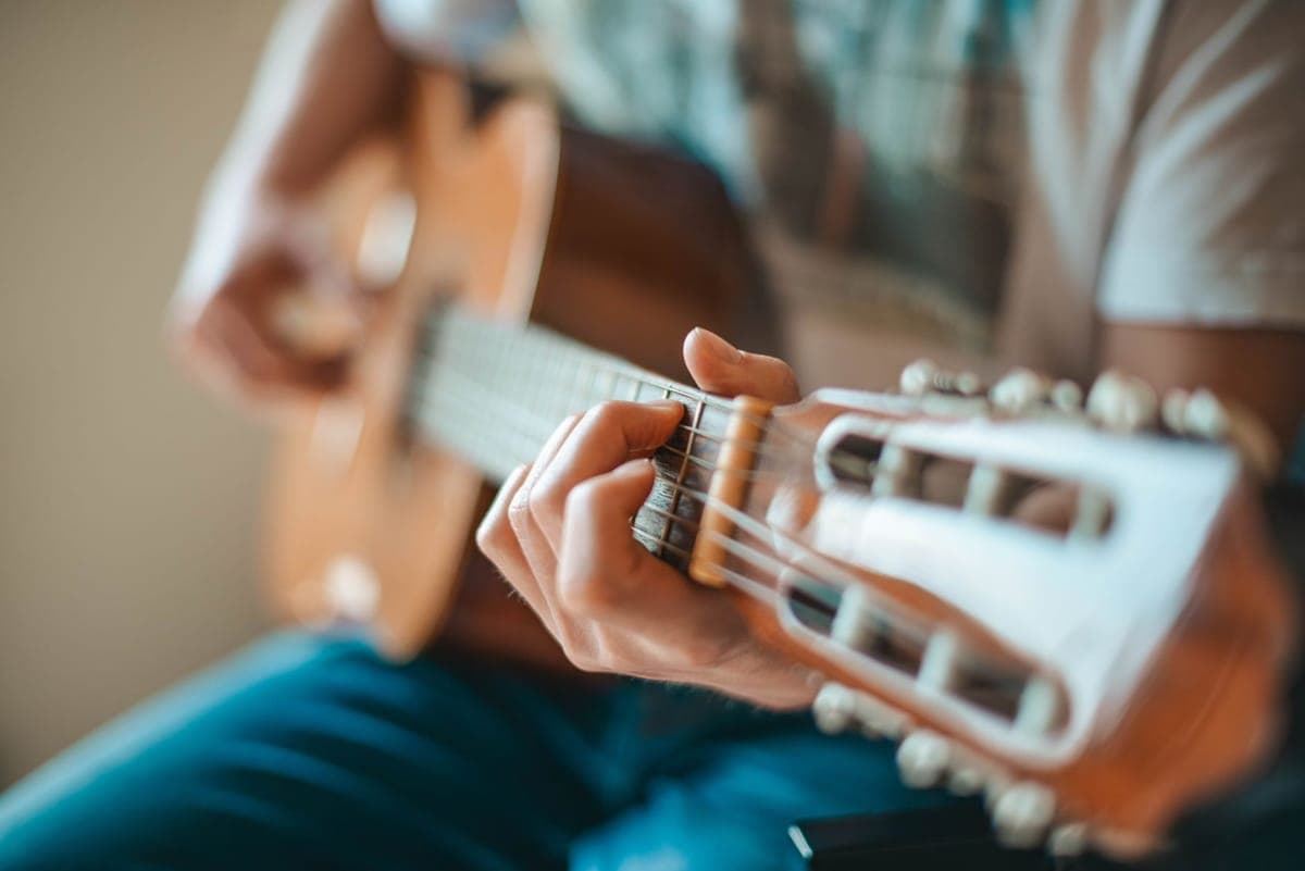 A guitar being restrung, with a winder on a tuning machine