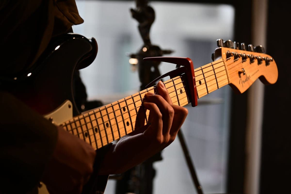 A capo positioned directly behind a fret on a guitar neck
