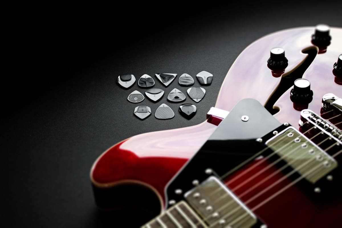 An assortment of guitar picks laid out on a dark surface