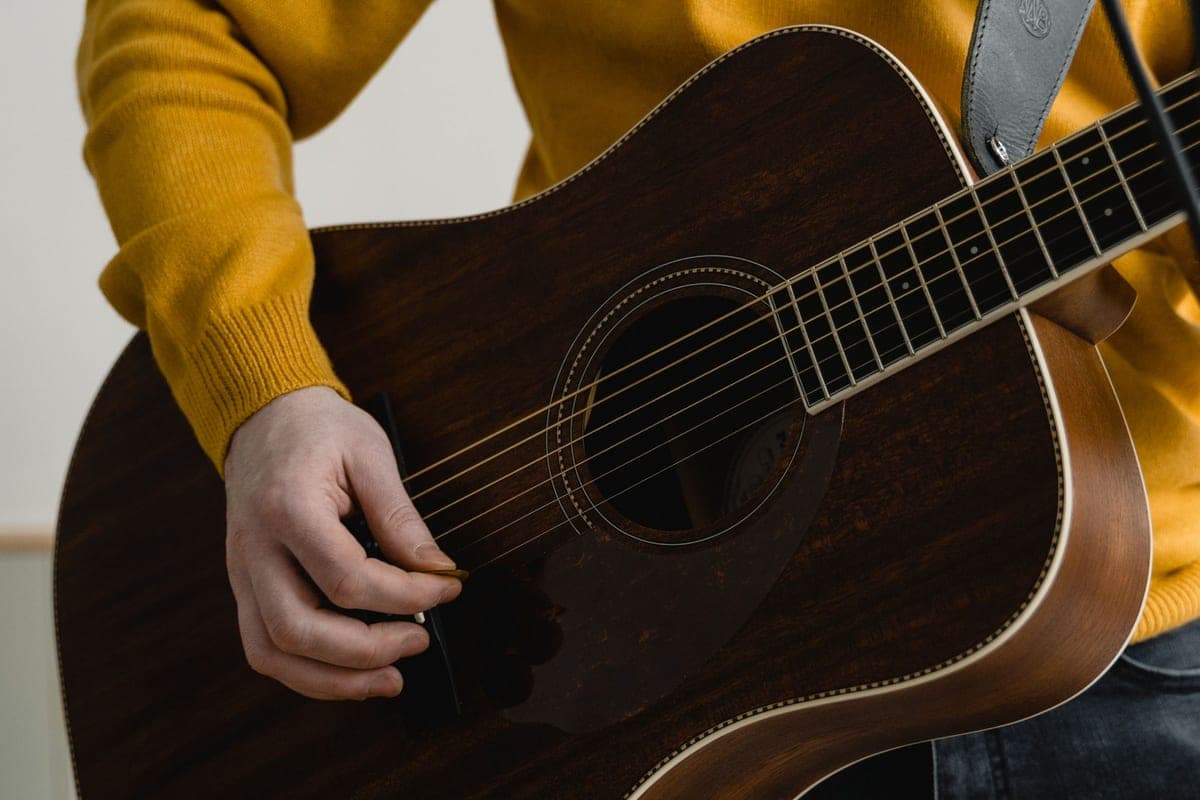 A hand strumming an acoustic guitar