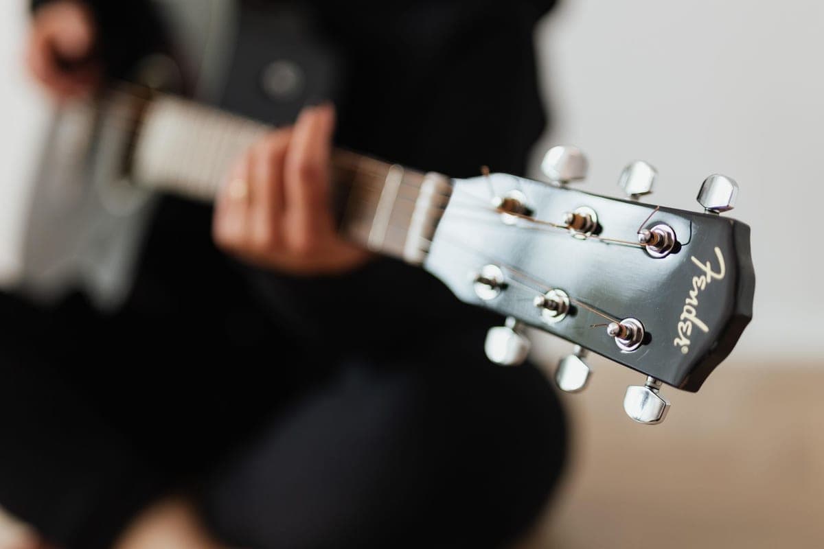 A close-up of the tuning pegs on an acoustic guitar headstock