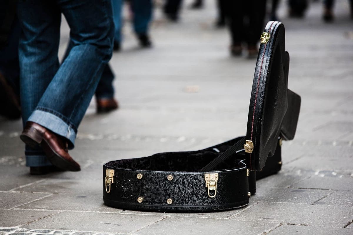 A padded guitar gig bag and a hardshell case side by side