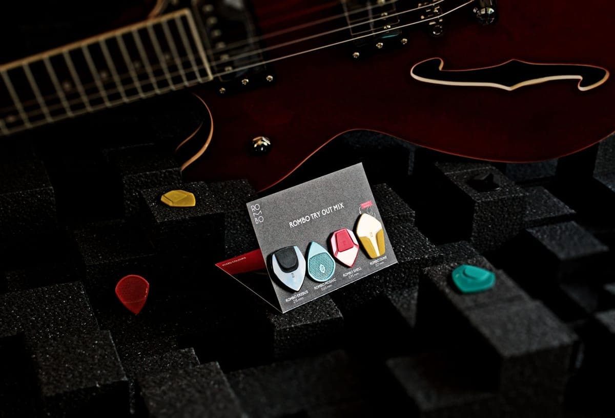 Guitar picks of several thicknesses scattered on a surface
